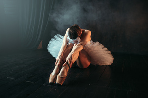 Ballet performer sits on floor